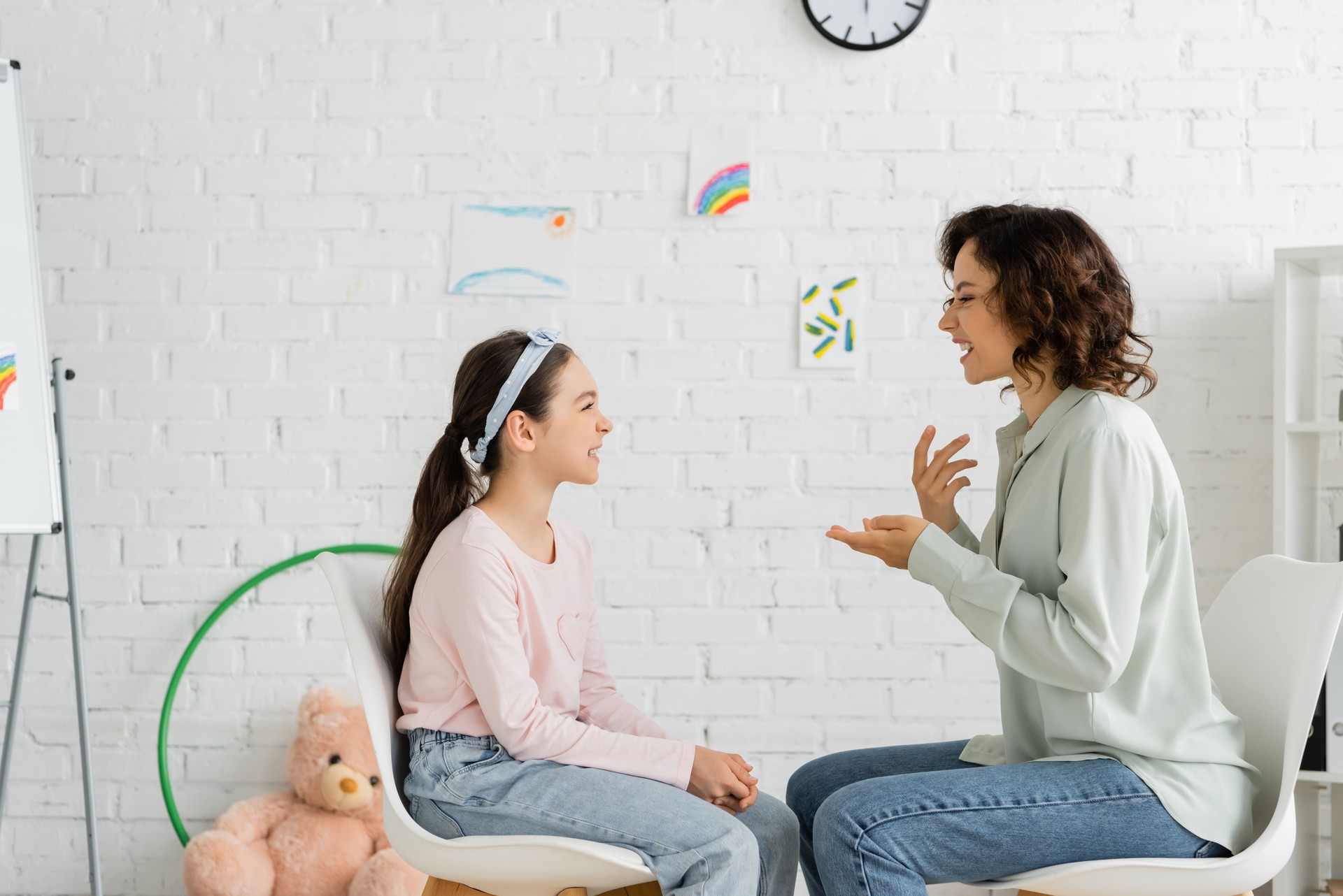 A speech therapist engages with a child in a warm and inviting consulting room